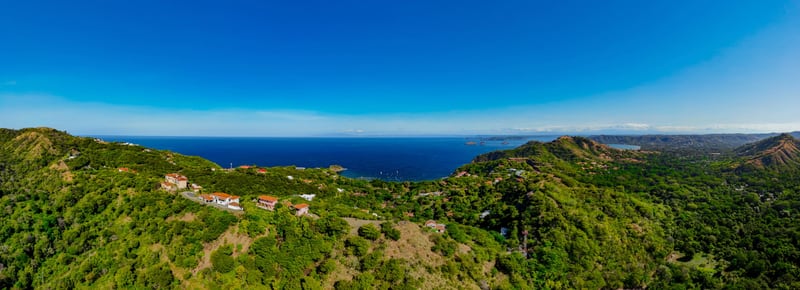 Wide view over the green hillsides above Ocotal with the Pacific stretching out beyond